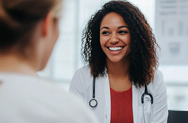 Woman talking with her smiling doctor